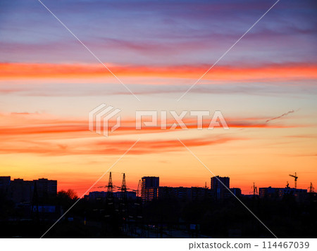 Sunset over city with orange-purple sky, perfect for reflective moods and backgrounds. 114467039