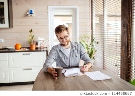 Serious applicant sitting in boardroom, preparing for interview with employer. Serious applicant sitting in boardroom, preparing for interview with employer. 114468697