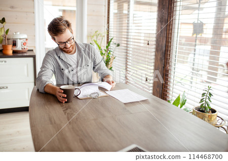 Serious applicant sitting in boardroom, preparing for interview with employer. Serious applicant sitting in boardroom, preparing for interview with employer. 114468700
