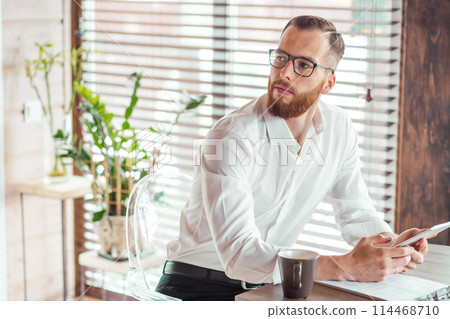 Serious applicant sitting in boardroom, preparing for interview with employer. 114468710