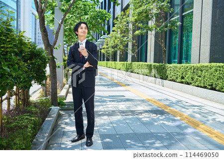 穿著西裝背著背包操作智慧型手機的商人 114469050