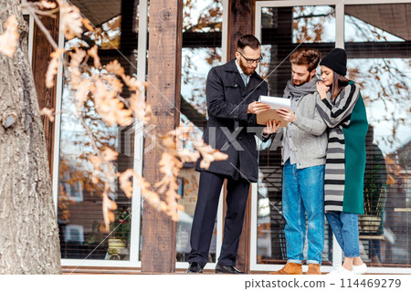 Young couple with real estate agent near house Young couple with real estate agent near house 114469279