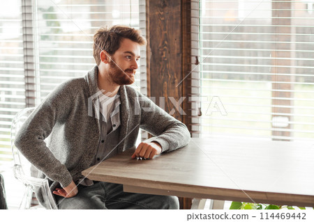 Serious applicant sitting in boardroom, preparing for interview with employer. 114469442