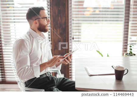 Serious applicant sitting in boardroom, preparing for interview with employer. 114469443