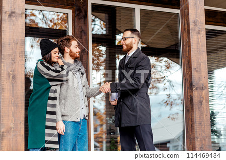 Young couple with real estate agent near house, real estate purchase Young couple with real estate agent near house, real estate purchase 114469484