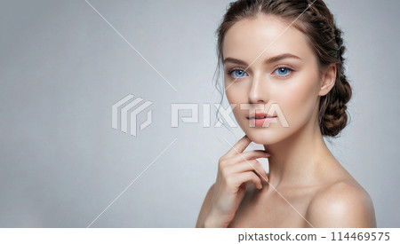 Portrait of young woman on gray background, perfect for skincare product advertisements. Her tranquil demeanor and natural beauty are mesmerizing. Portrait of young woman on gray background, perfect for skincare product advertisements. Her tranquil demeanor and natural beauty are mesmerizing. 114469575