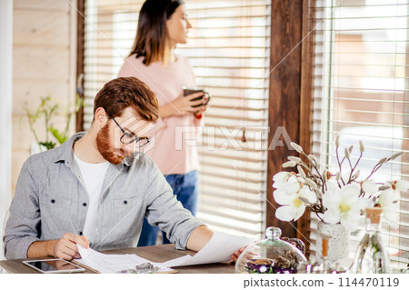 Serious applicant sitting in boardroom, preparing for interview with employer. Serious applicant sitting in boardroom, preparing for interview with employer. 114470119
