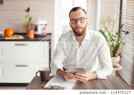 Serious applicant sitting in boardroom, preparing for interview with employer. Serious applicant sitting in boardroom, preparing for interview with employer. 114470127