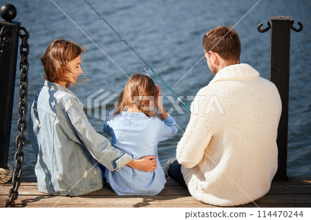happy family with daughter fishing in pond in fall happy family with daughter fishing in pond in fall 114470244