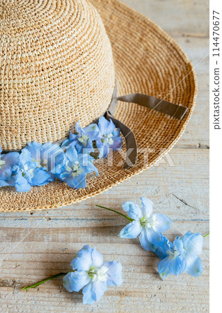 Blue flowers and straw hats that evoke summer 114470677