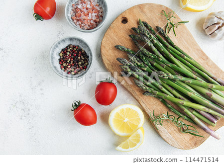 Fresh Asparagus on a Wooden Cutting Board With Seasonal Ingredients Fresh Asparagus on a Wooden Cutting Board With Seasonal Ingredients 114471514