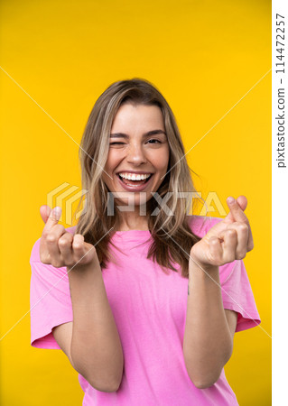 Happy emotions concept. Positive and beautiful young woman laughs poisitively looks aside with carefree face expression wears casual orange sweater isolated over yellow studio background. 114472257
