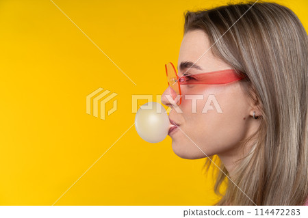 Happy emotions concept. Positive and beautiful young woman laughs poisitively looks aside with carefree face expression wears casual orange sweater isolated over yellow studio background. 114472283