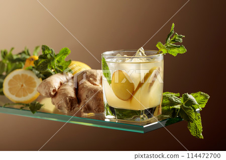 Ginger ale beer cocktail with lemon and mint in a frozen glass. Ginger ale beer cocktail with lemon and mint in a frozen glass. 114472700