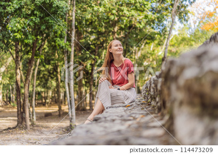Woman tourist at Coba, Mexico. Ancient mayan city in Mexico. Coba is an archaeological area and a famous landmark of Yucatan Peninsula. Cloudy sky over a pyramid in Mexico Woman tourist at Coba, Mexico. Ancient mayan city in Mexico. Coba is an archaeological area and a famous landmark of Yucatan Peninsula. Cloudy sky over a pyramid in Mexico 114473209