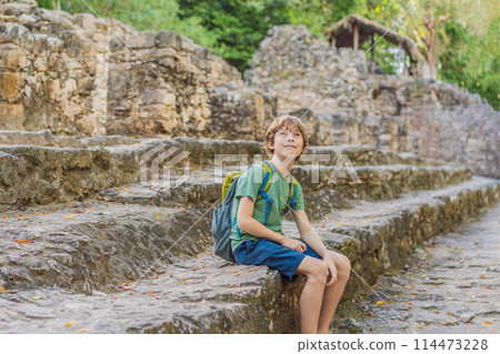 Boy tourist at Coba, Mexico. Ancient mayan city in Mexico. Coba is an archaeological area and a famous landmark of Yucatan Peninsula. Cloudy sky over a pyramid in Mexico Boy tourist at Coba, Mexico. Ancient mayan city in Mexico. Coba is an archaeological area and a famous landmark of Yucatan Peninsula. Cloudy sky over a pyramid in Mexico 114473228