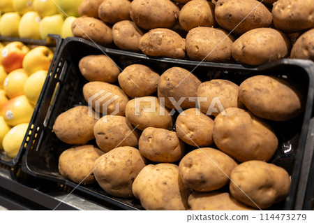 Collection of potatoes on a sale on a counter of market. bio vegetables sold on market stall. Agriculture and harvesting, food concept Collection of potatoes on a sale on a counter of market. bio vegetables sold on market stall. Agriculture and harvesting, food concept 114473279