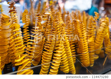 Potatoes cut into a spiral and fried. Tornado potato. A bunch of twisted potatoes. Delicious savory street food. Potatoes cut into a spiral and fried. Tornado potato. A bunch of twisted potatoes. Delicious savory street food. 114473280
