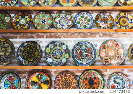 An assortment of handmade Uzbek plates with colorful traditional patterns An assortment of handmade Uzbek plates with colorful traditional patterns 114473420