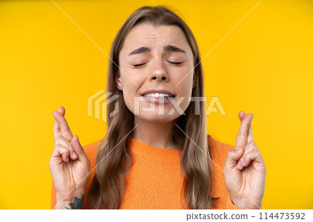 Happy emotions concept. Positive and beautiful young woman laughs poisitively looks aside with carefree face expression wears casual orange sweater isolated over yellow studio background. 114473592