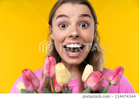 Happy emotions concept. Positive and beautiful young woman laughs poisitively looks aside with carefree face expression wears casual orange sweater isolated over yellow studio background. 114474144