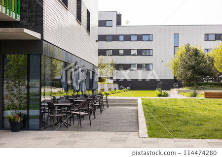 Modern outdoor terrace with seating arrangement. Fashionable outdoor cafe or restaurant tables, summer time 114474280