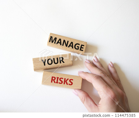 Manage your Risks symbol. Concept words Manage your Risks on wooden blocks. Businessman hand. Beautiful white background. Business and Manage your Risks concept. Copy space. Manage your Risks symbol. Concept words Manage your Risks on wooden blocks. Businessman hand. Beautiful white background. Business and Manage your Risks concept. Copy space. 114475385