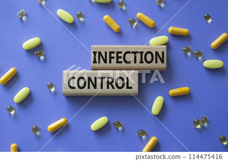 Infection Control symbol. Concept word. Infection Control on wooden blocks. Beautiful purple background with pills. Medicine and Infection Control concept. Copy space 114475416