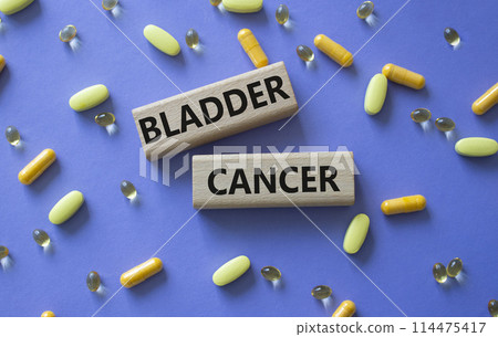 Bladder Cancer symbol. Concept word Bladder Cancer on wooden blocks. Beautiful purple background with pills. Medicine and Bladder Cancer concept. Copy space 114475417