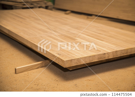 Oak wood panels from which tables will be made.Focus on the foreground Oak wood panels from which tables will be made.Focus on the foreground 114475504
