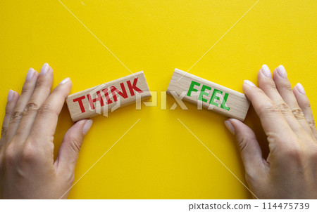 Think or Feel symbol. Concept word Think or Feel on wooden blocks. Businessman hand. Beautiful yellow background. Business and Think or Feel concept. Copy space Think or Feel symbol. Concept word Think or Feel on wooden blocks. Businessman hand. Beautiful yellow background. Business and Think or Feel concept. Copy space 114475739