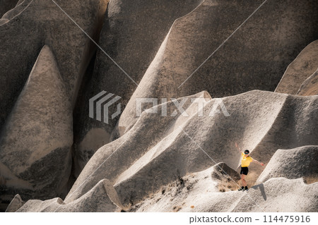 Woman tourists standing on stony mountain in Cappadocia, Turkey 114475916