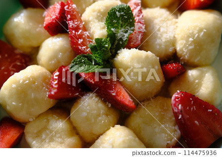 Delicious lazy dumplings with berries, sour cream, mint leaves. Perfect for culinary projects, food-related content, or advertisements. 114475936
