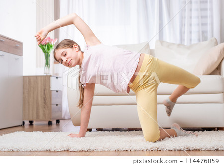 Motivated teen doing casual exercises for warming up, indoors 114476059