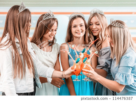 Happy girls in diadems with cocktails at celebration party 114476387