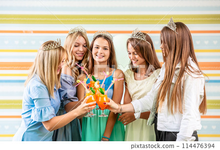 Girls drinking cocktails at a party Girls drinking cocktails at a party 114476394
