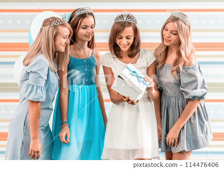 Nice friends giving present to happy birthday girl 114476406