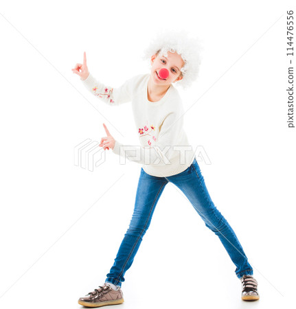 Young teenage girl in white wig and red nose pointing up with fingers while looking at camera isolated on white background Young teenage girl in white wig and red nose pointing up with fingers while looking at camera isolated on white background 114476556