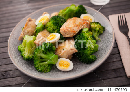 Chicken breast with broccoli and quail eggs on plate for healthy dinner 114476793