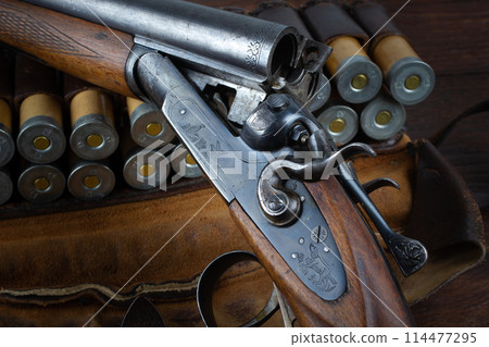 double barreled side shotgun with cartridges in bandolier. 114477295