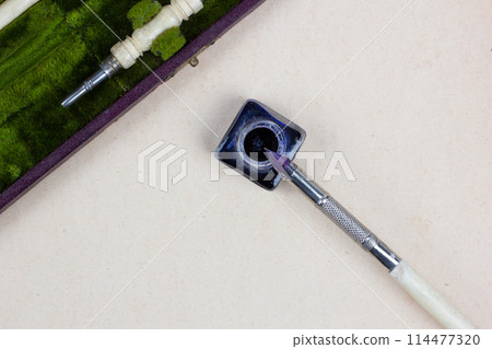 Vintage pen and inkwell on paper background 114477320