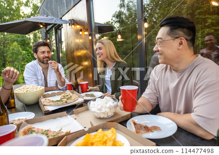 Overjoyed friends meeting for picnic together having fun with alcohol 114477498