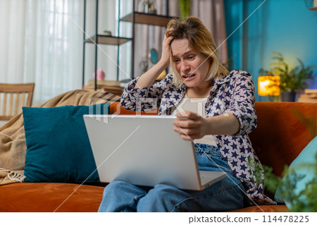 Sad woman using laptop notebook typing browsing working loses bad news game fail computer virus 114478225