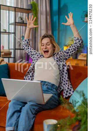 Happy woman using laptop receive good news shocked by victory celebrate lottery jackpot win at home Happy woman using laptop receive good news shocked by victory celebrate lottery jackpot win at home 114478230