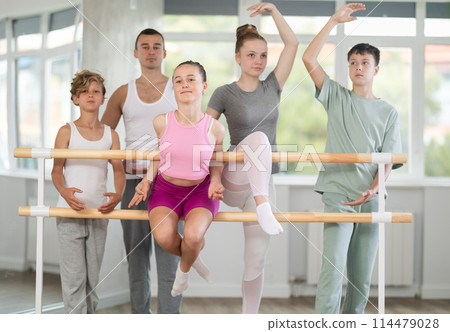 Teenage boys and girls posing with ballet-master in dancehall Teenage boys and girls posing with ballet-master in dancehall 114479028
