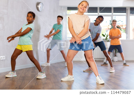 Dancing group of five children practicing new dance in modern studio 114479087