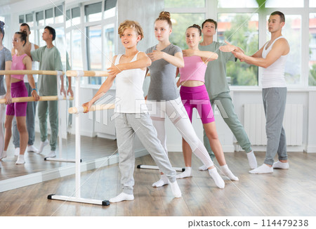 Teenage boys and girls practicing battement tendu position of ballet in dancehall 114479238