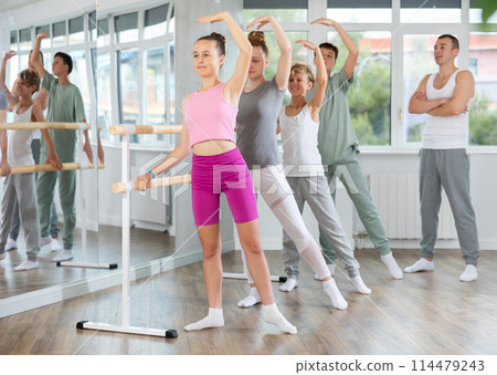 Teenage boys and girls practicing battement tendu position of ballet in dancehall 114479243