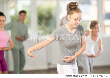 Teenage girl practicing ballet positions in dance studio 114479257