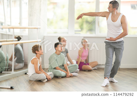 Male dancer performing pirouette in front of class 114479292